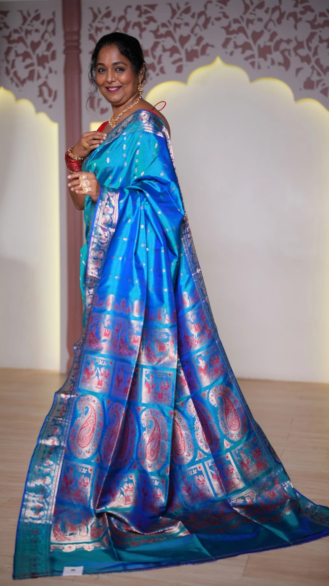 Woman wearing a blue and red Baluchari silk saree